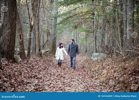 Romantic Young Couple Holding Hands Walking In The Woods Stock Image