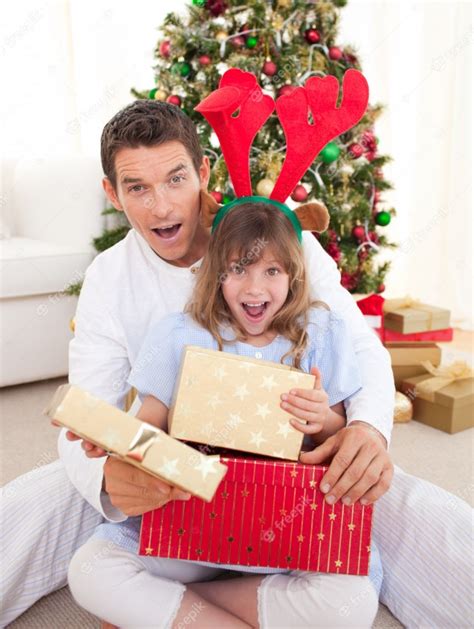 Sorprendido Padre Y Su Niña Abriendo Regalos De Navidad Foto Premium