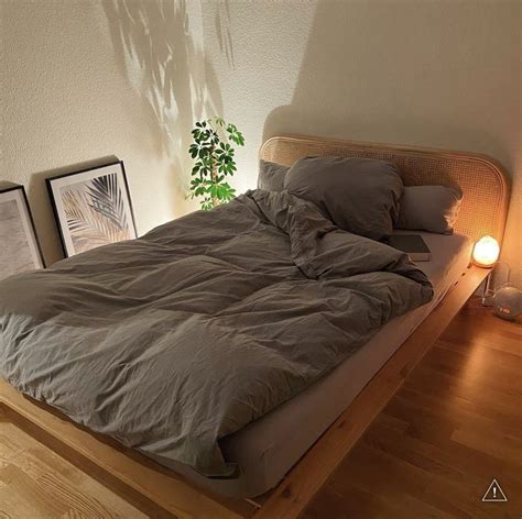A Bed Sitting On Top Of A Wooden Floor Next To A Lamp