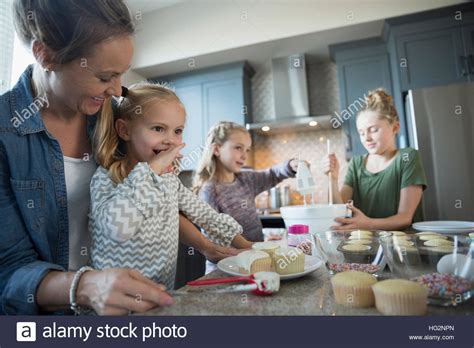 Madre Y Sus Hijas En La Cocina Para Hornear Glaseado Cupcakes