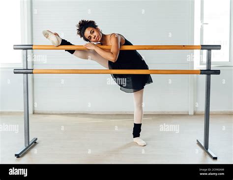 Young Ballerina Stretching Her Leg In Dance Studio Woman Doing