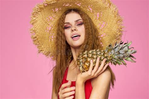 Woman With A Gun In Hands Of A Straw Hat Bright Makeup Exotic Fruits Summer Pink Background