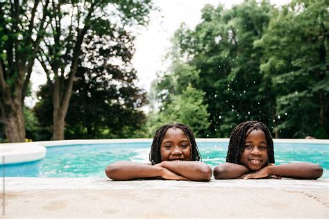 two african american girls by the edge of a swimming pool del colaborador de stocksy gabi