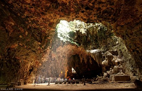 People Are Standing In The Entrance To A Cave