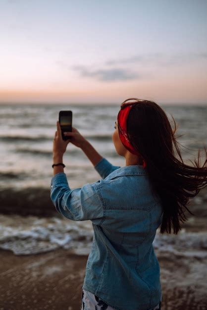 Premium Photo Beautiful Girl Takes A Selfie On The Beach At Sunset The Concept Of Relax Travel