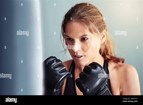 Throwing Some Punches A Female Boxer Working Out With A Punching Bag