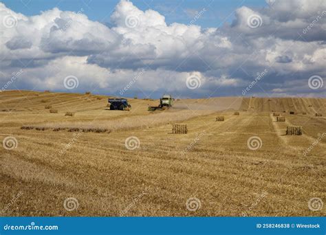 Beautiful Shot Of The Sky While Tractors Make Straw Bales In A Wheat
