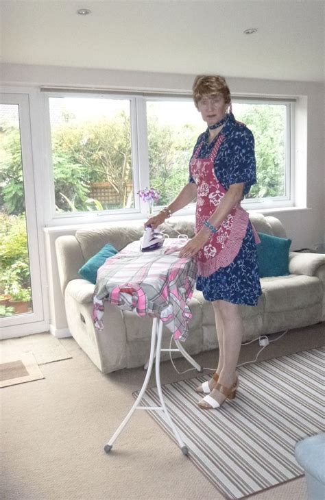 A Woman Ironing Clothes On An Ironing Board In Front Of A Large Window