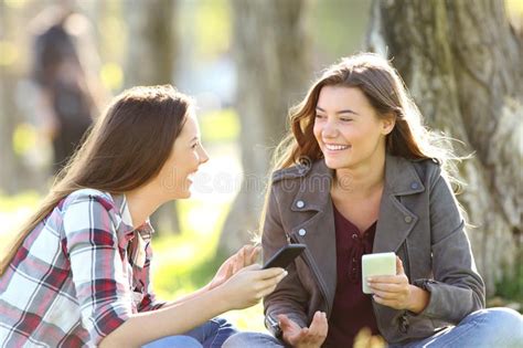 Two Friends Talking Holding Their Smart Phones Two Happy Friends Talking And La AFFILIATE