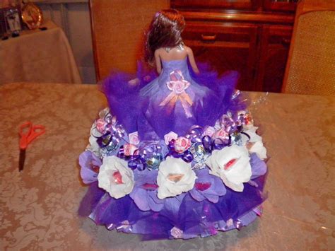The Doll Is Dressed In A Purple Dress With White Flowers On It S Skirt