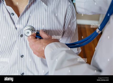 Caucasian Doctor Listening To Heartbeat Of Patient Stock Photo Alamy