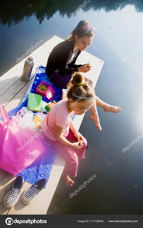 Girls Sitting Pier Stock Photo By ©imagesource 171725540