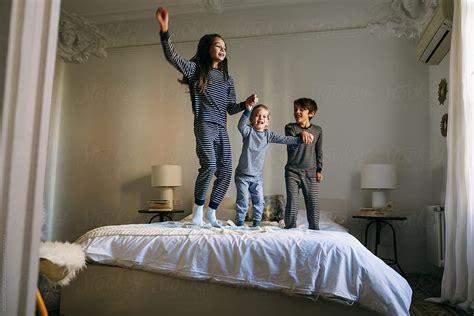 Kids Wearing Pajama Jumping On Bed By Stocksy Contributor