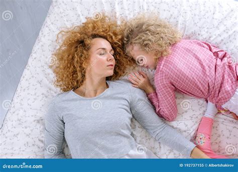 Tired Ginger Woman Is Sleeping With Her Adorable Daughter Stock Image