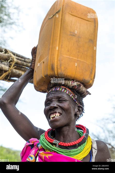 Smiling Toposa Tribe Woman Carrying A Jerrycan On Her Head Namorunyang