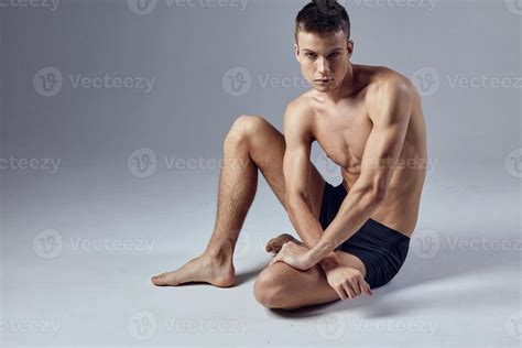 Male Athlete Sitting On Floor With Pumped Up Body Posing 22252219 Stock