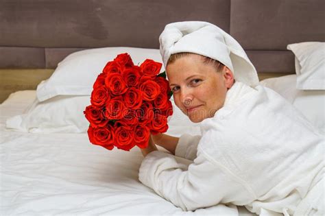 Elegant Romance Stunning Girl With A Large Bouquet Of Red Roses On A Hotel Bed Relaxation