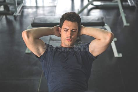 Handsome Man Exercising Doing Sit Up Abdominal Exercise In Gym Stock