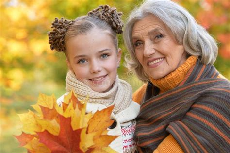Portrait Of Granny And Granddaughter Posing Outdoors Stock Photo