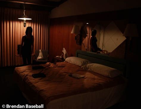 Two People Are Standing In The Dark Near A Bed