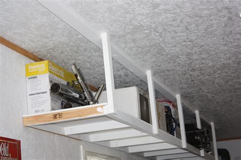 Overhead garage storage shelf fits perfectly above the garage door to store her tool belt. Ana White | Overhead Garage Storage - DIY Projects