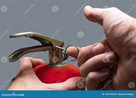 A Man Pulls Out A Safety Ring From A Red Fire Extinguisher Close Up Male Finger Pulls Out A
