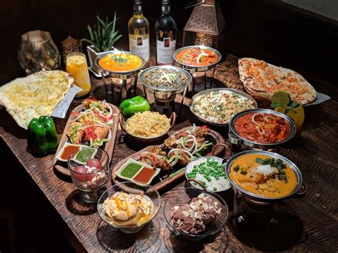 A Wooden Table Topped With Lots Of Different Types Of Food And