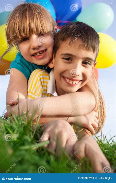 Happy Smiling Children Lying On The Green Grass With Colorfull B Stock
