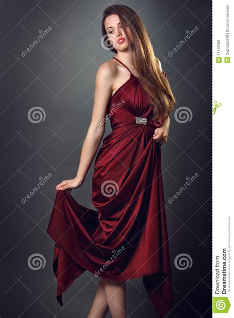 Elegant Fashion Model Poses With Red Dress Of Silk Stock