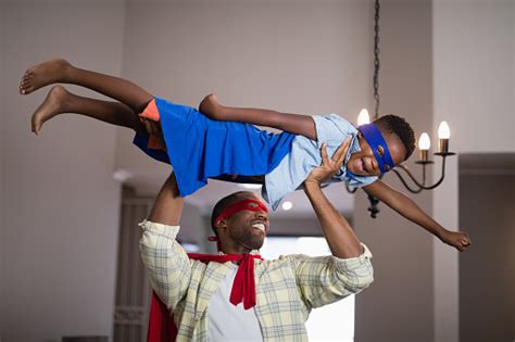 Playful Father And Son In Superhero Costume At Home Stock ...