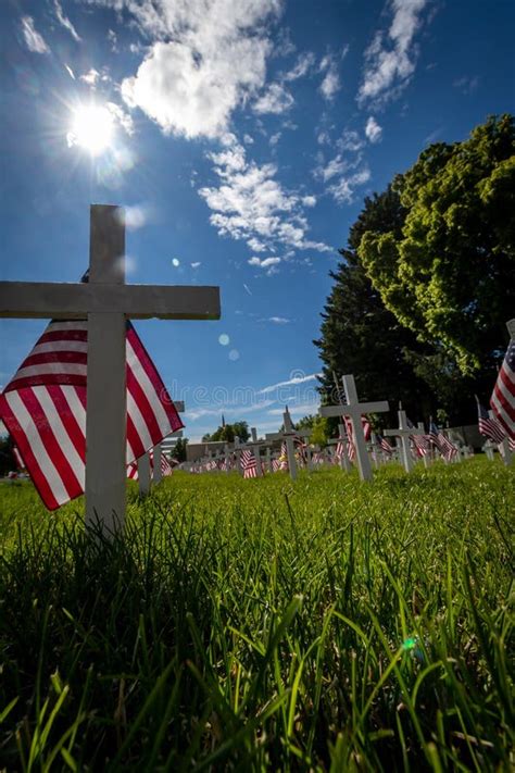 White Cross Military Grave Markers Decorated With American Flags For