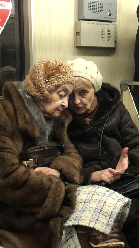 two older women sitting on a subway train