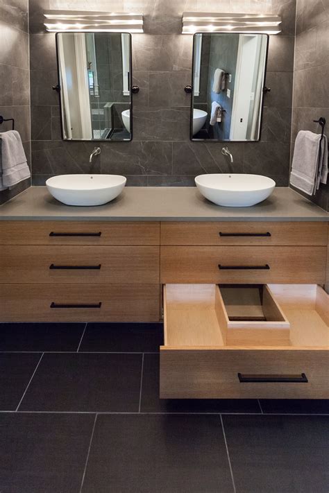 Full Tiled Master Bathroom Featuring Floating Vanity With Vessel Sinks