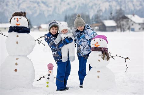 familie mit kindern errichtender schneemann im park in wenig vil stockbild bild von spiel