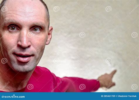 emotional european mature male wearing red t shirt pointing his index finger up at blank wall
