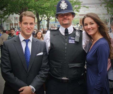 Two Men And A Woman Standing Next To Each Other In Front Of A Police