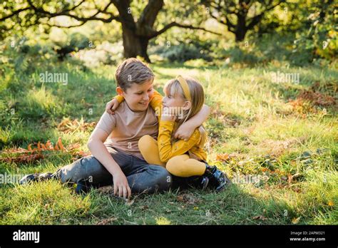 Two Girls Sit Arm In Arm On A Meadow Hi Res Stock Photography And