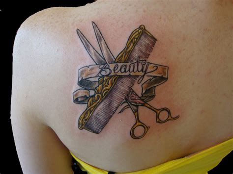 Scissor And Comb With Beauty Banner Tattoo On Back Shoulder