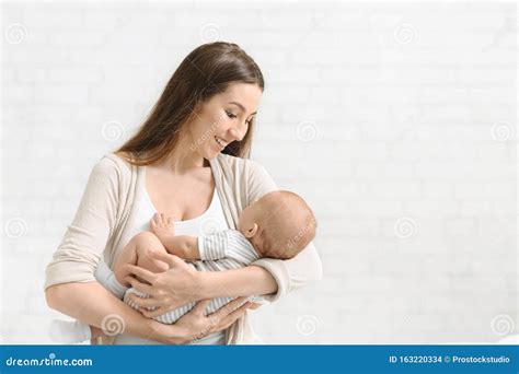Pretty Young Woman Holding A Newborn Baby In Her Arms Stock Photo