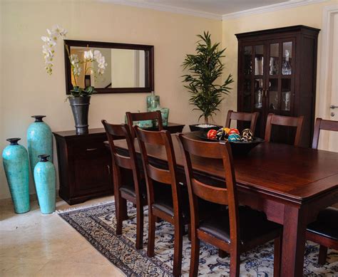 a dining room table with chairs and vases