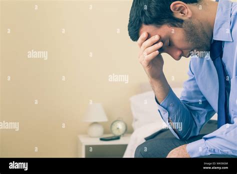 Sad Man Sitting Head In Hands On His Bed Stock Photo Alamy