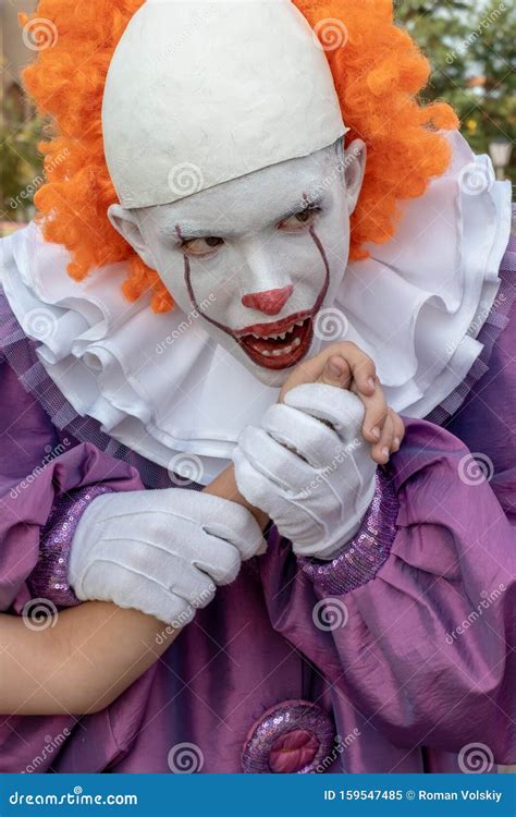 A Guy In A Scary Clown Costume With Sharp Teeth Holds Someone Else S
