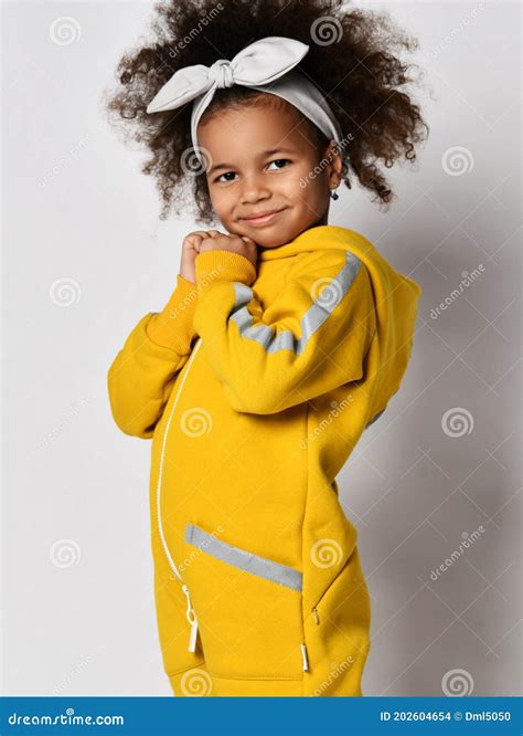 Retrato De Uma Menina Mulata Sorridente E Fofa De Macacão Amarelo
