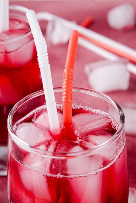 cold cherry drink with ice cubes and cocktail tubes in glasses on pink background stock image
