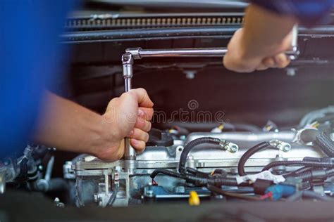 Mechanic Working On Car Engine In Auto Repair Shop Stock Photo Image