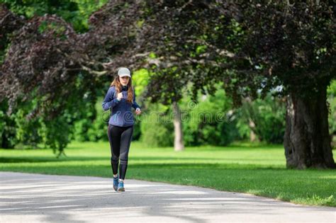 Young Woman Jogging In Park On Sunny Day Stock Photo Image Of Woman