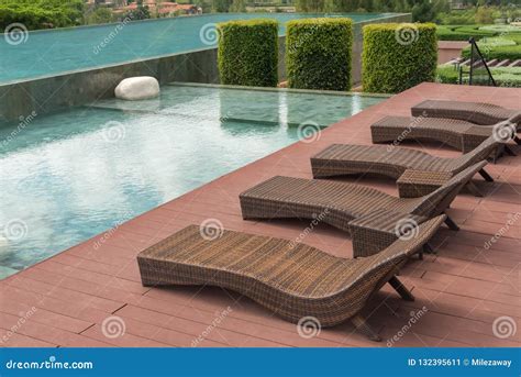 Brown Rattan Sofa Bed Or Bench Chair Beside Beautiful Swimming Pool