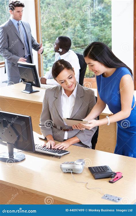 Businessmen And Businesswomen Working In Busy Office Stock Image