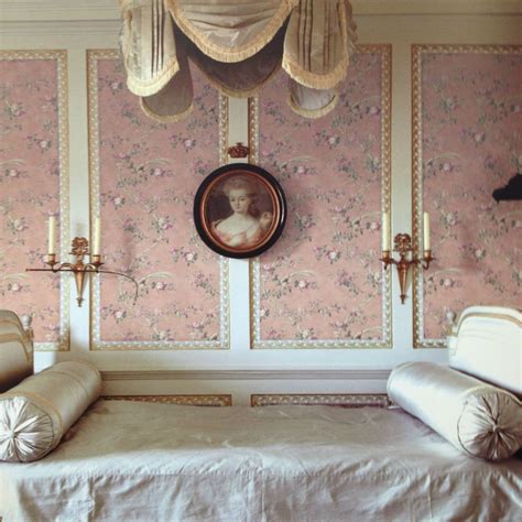 A Bedroom With Pink Wallpaper And White Bedding