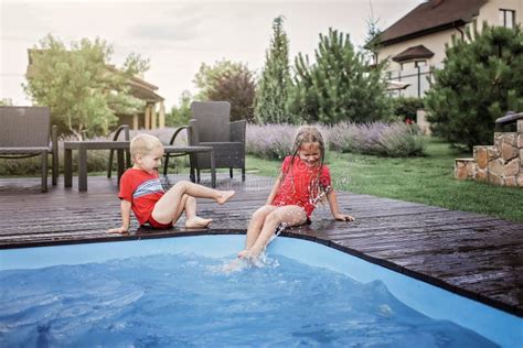 Happy Cute Sibling Boy And Girl Have A Fun And Splashing Each Other